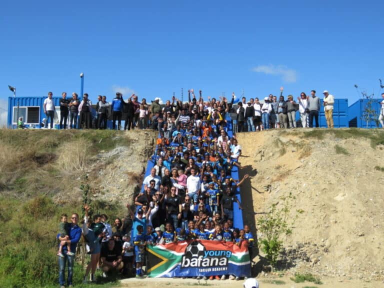 A crowd standing on stairs with a Young Bafana banner celebrating the YB Arena opening.
