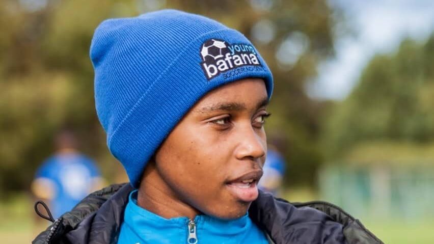 A Young Bafana player wearing a blue hat and looking to the side.