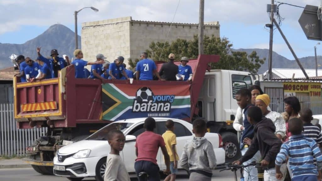 Young Bafana Soccer Academy senior team celebrating their victory in the ABC League on top of a truck in the township.