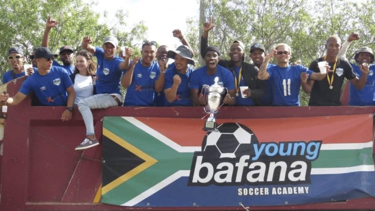 Young Bafana Soccer Academy senior team celebrating their victory in the ABC League on top of a truck.