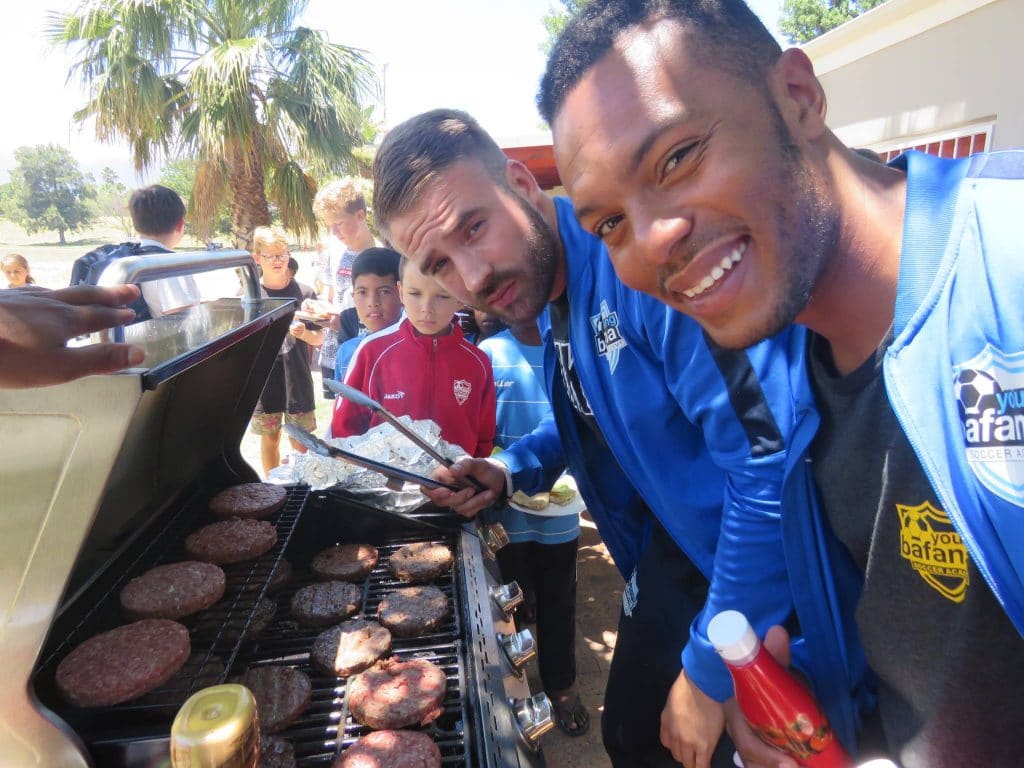 Members of the Young Bafana Soccer Academy having a barbeque.
